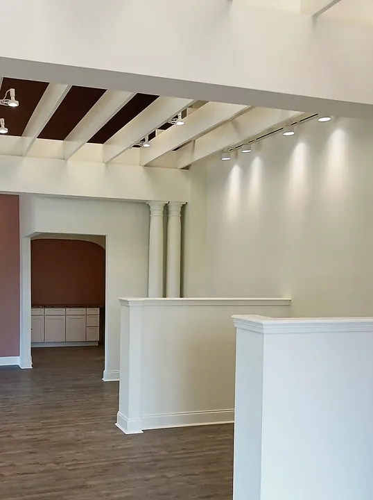 Commercial space with white trim, columns, half walls and new plank flooring