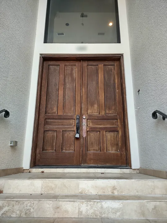 Weathered double wood entry doors before refinishing
