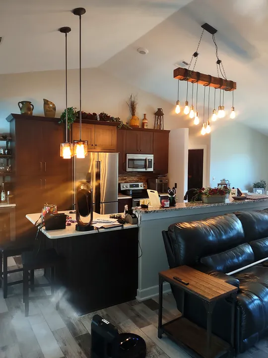 Finished open kitchen with dark wood cabinets, granite breakfast bar and plank floors