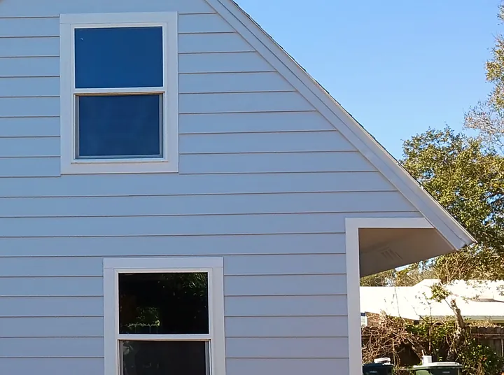 After: new lap siding painted light gray with white window trim