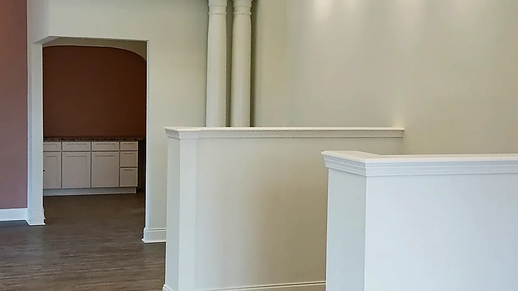 Finished interior with white trim, columns and half walls