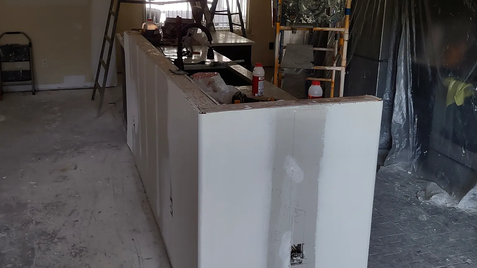 Kitchen repair in progress with new drywall on the island